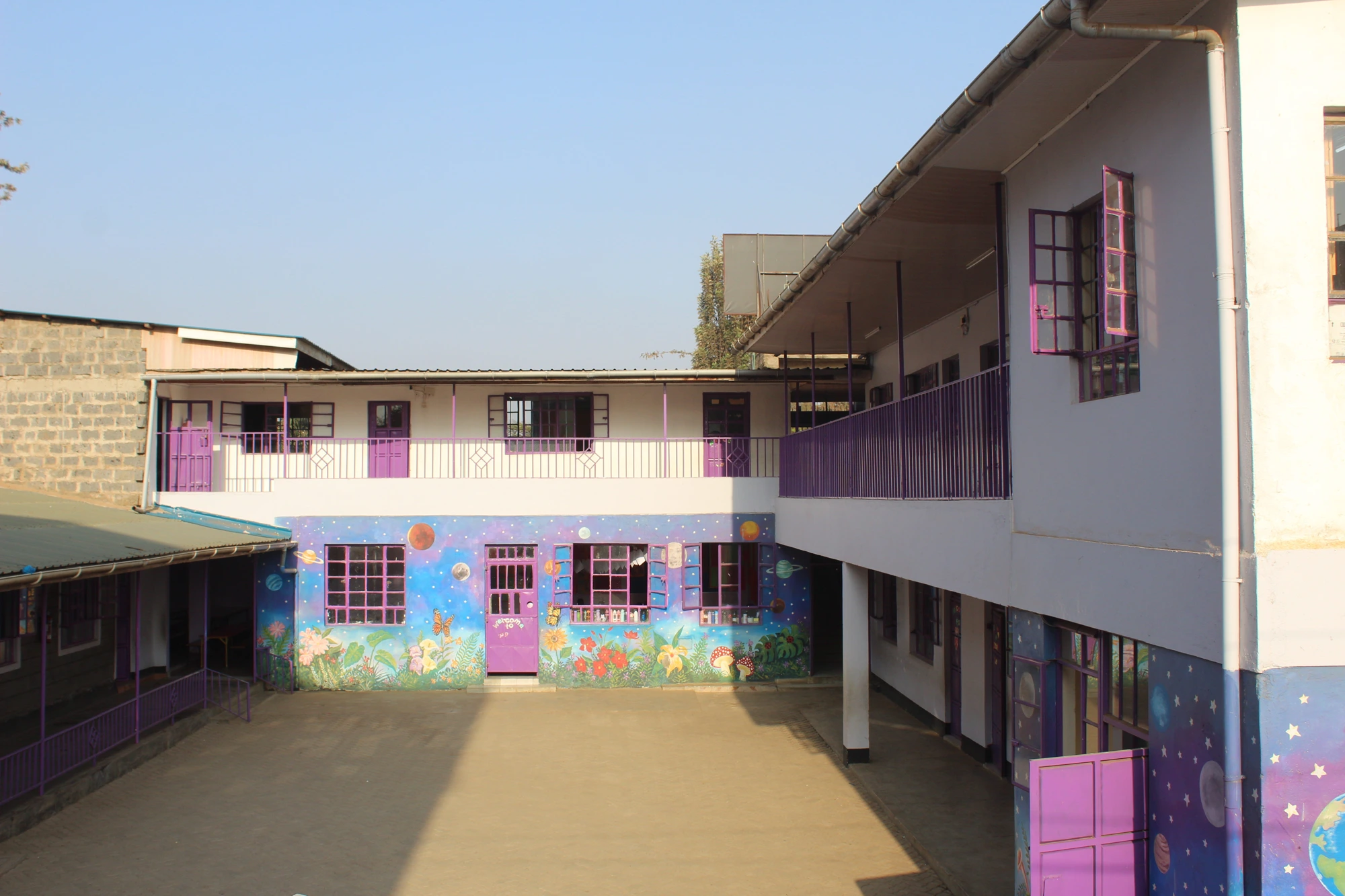 Rainbow Campus courtyard with purple windows and colourful classroom murals